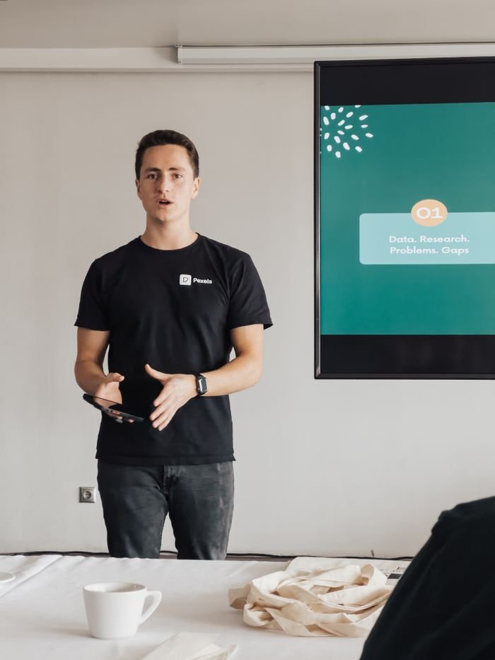 A young man presents data and research in a modern office setting.